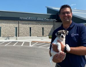 Executive Director Shawn Morey holding white and black dog
